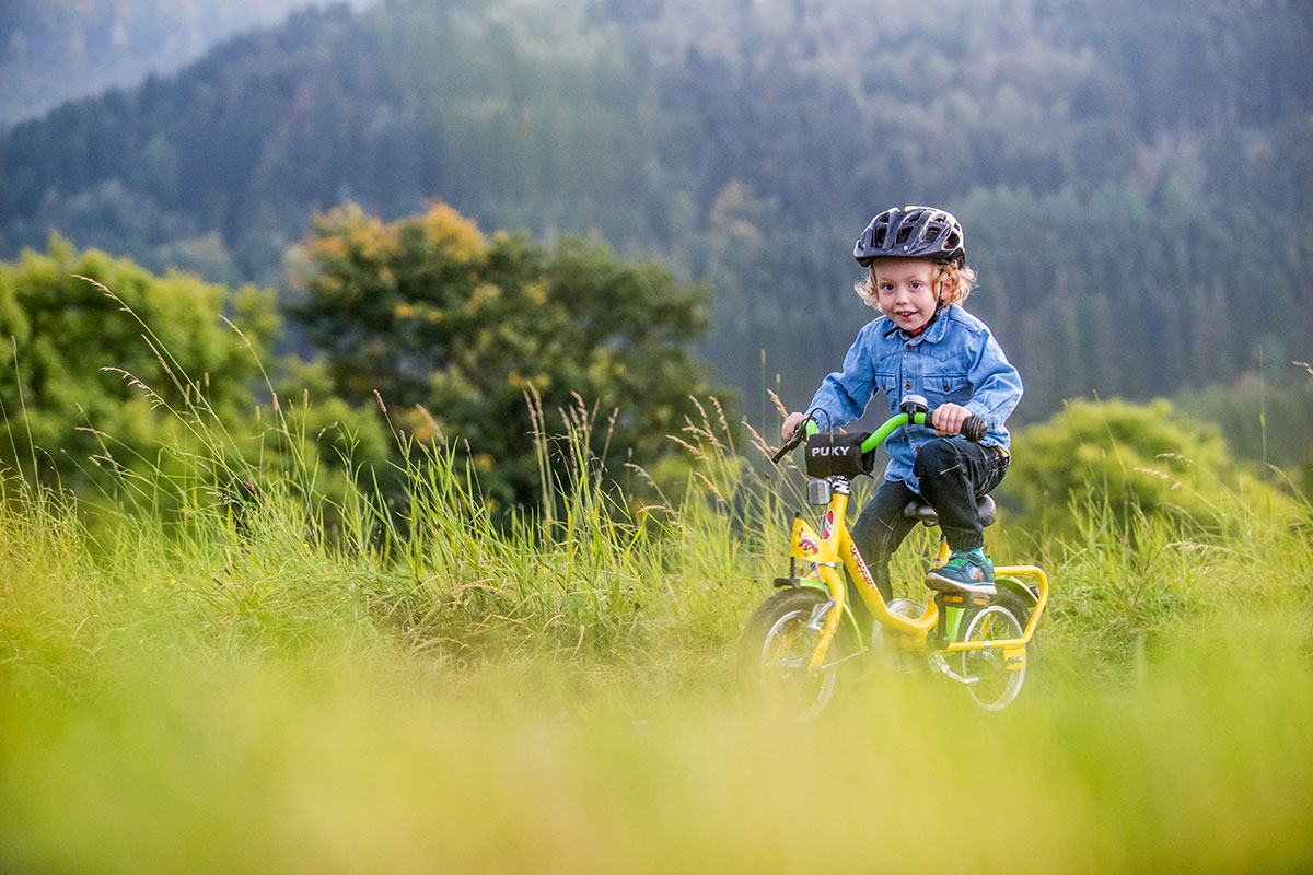 Kleines Kind mit Helm auf einem Fahrrad